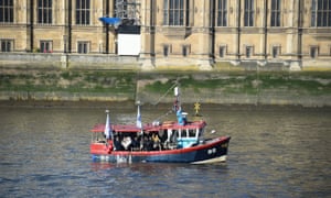 The âFishing for Leaveâ boat passes the Houses of Parliament on the Thames in London.