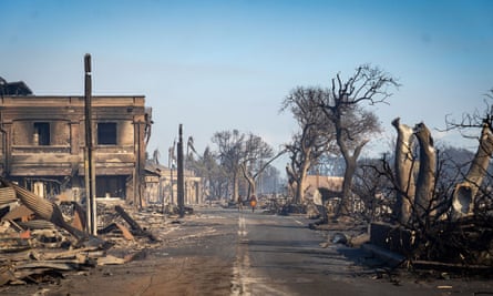 Mahalle sakinleri Çarşamba günü bir sokakta yürürken yangından sonra yıkılan binalar ve yanan ağaçlar.  Lahaina şehrinin büyük bir kısmı, Salı gecesi kasıp kavuran orman yangını nedeniyle neredeyse tanınmayacak kadar değişti.
