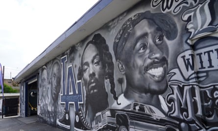 A long, one-story wall adorned with a black-and-white mural and blue Los Angeles Dodgers logo.
