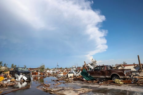 Damaged pickup trucks sit among debris after a tornado passed through a residential area in Perryton, Texas.