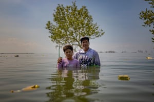 William Gregorio and his son stand in deep sea water