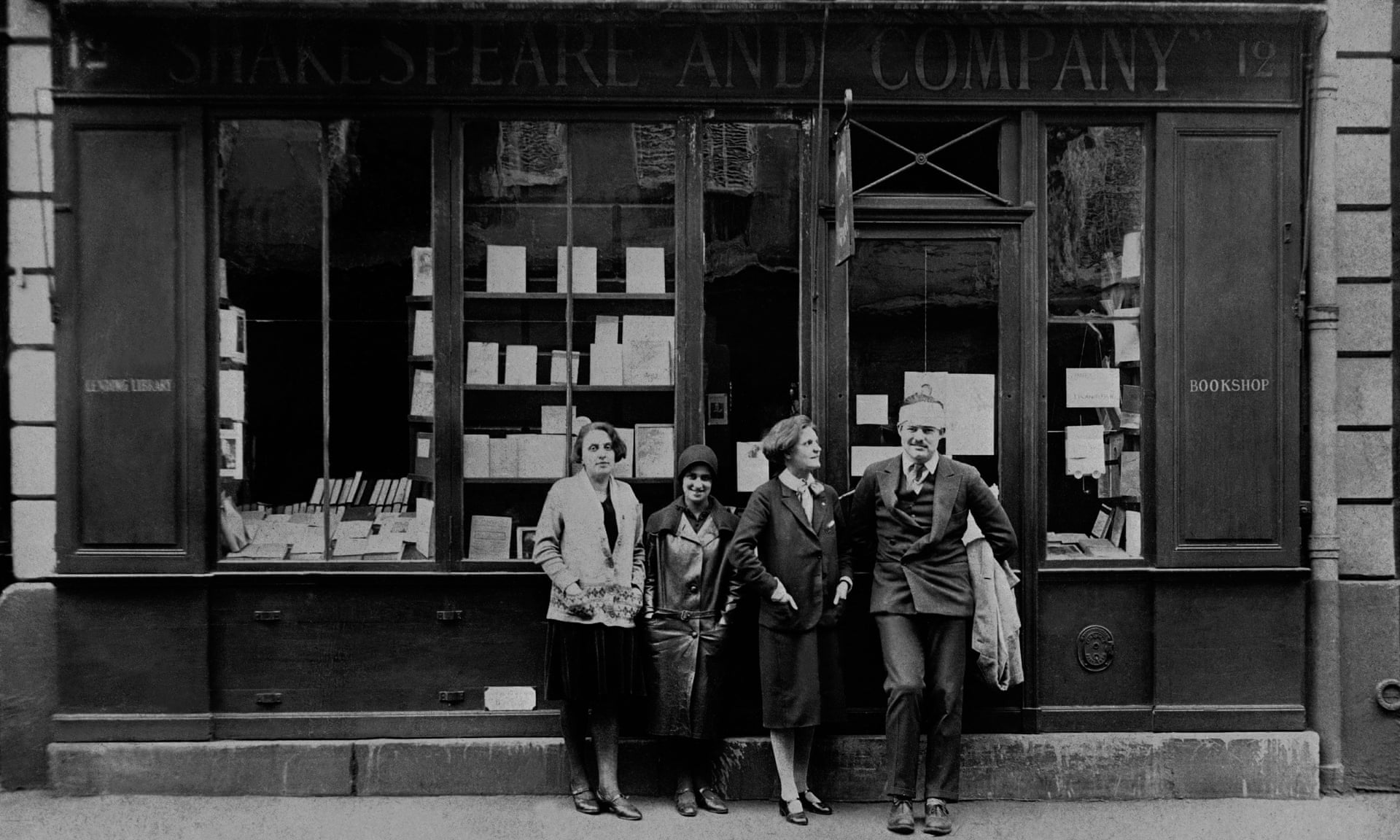 Hemingway (right) with Sylvia Beach (third from left) and two others outside Shakespeare and Company in 1926. From the Guardian.
