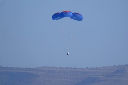 Parachutes carry the Blue Origin capsule with passengers William Shatner, Chris Boshuizen, Audrey Powers and Glen de Vries down to the spaceport near Van Horn, Texas, on Wednesday.