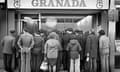 Phil Loach's photograph, The Grand National, Brierley Hill High Street, 1976, showing the backs of a crowd of people clustered around the Granada TV shop to watch the race.