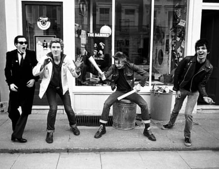 Band pose in front of shop. Rat Scabies sits on dustbin, pretending to drum