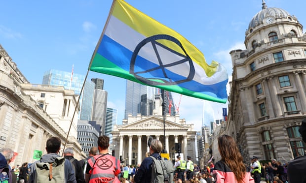 Extinction Rebellion demonstrators with XR flag at Bank junction in front of the Bank of England in the City of London.