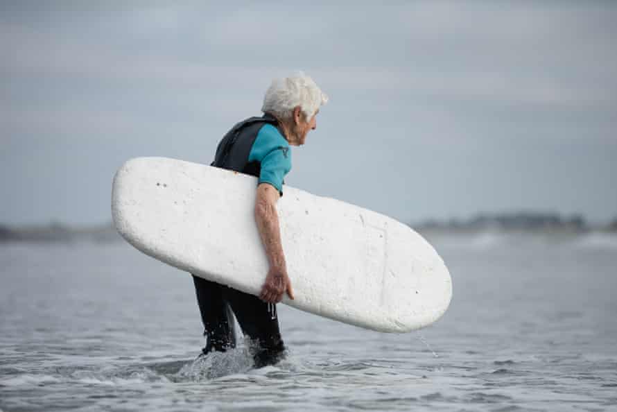 Meherne heads out for a wave in the middle of winter, in a summer wetsuit.