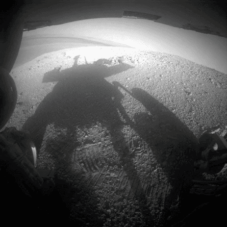 The Mars Exploration Rovers were not capable of shooting selfies, but they frequently caught their own shadows in late afternoon. The camera that took this photo is mounted on the rear body of the rover, and the two back wheels are visible at the sides.