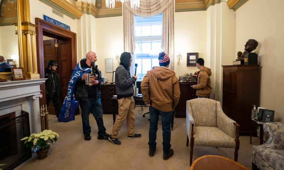 Donald Trump supporters stand in the office of House speaker Nancy Pelosi, where a laptop was stolen.