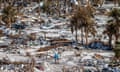 Two people walk among debris on an RV park in Fort Myers beach, Florida, US, in 2022 after Hurricane Ian swept across the area.