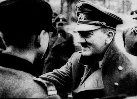 Black and white photo of Hitler pinning a badge or medal to a young man