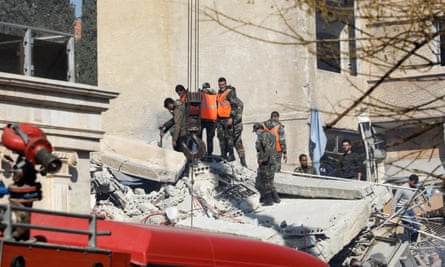 Security personnel search the rubble of a building destroyed in a reported Israeli strike in Damascus on January 20, 2024