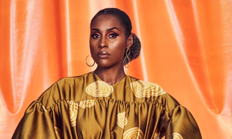 Issa Rae in a gold dress against an orange backdrop