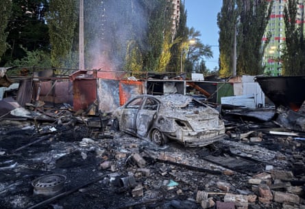 Burned out car and other rubble in street