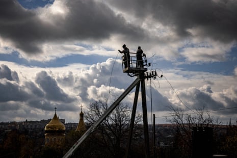 Communal workers repair power lines cut by shelling in the town of Kupiansk, Kharkiv region.