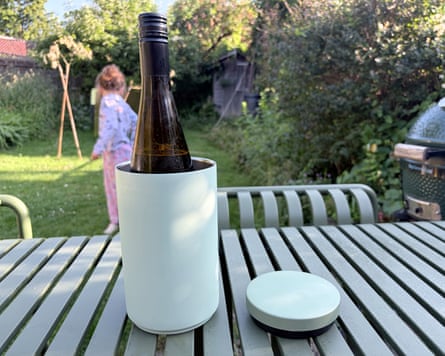 A bottle of wine in a Design Letters wine cooler on a garden table.