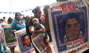 Relatives of the missing students hold signs that read in Spanish “We are missing 43 – where are they?” after they listened to the international experts’ report, in Mexico City Sunday.