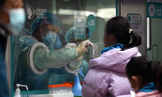 A health worker gives a girl a Covid test in Beijing