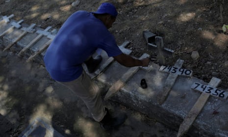 A gravedigger paints numbers on crosses at the Sao Francisco Xavier cemetery in Rio de Janeiro during the coronavirus pandemic.