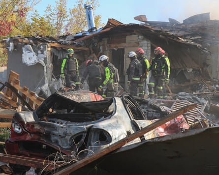 Firefighters outside a house destroyed in the attack