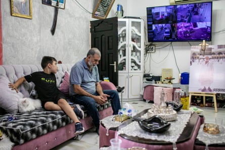 Zohar Rajabi and one of his grandchildren, sitting at their home, in the Palestinian neighbourhood of Batn al-Hawa in East Jerusalem