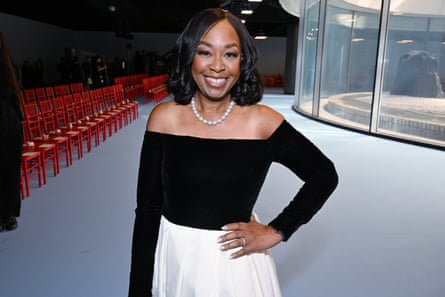 Shonda Rhimes in 2025, wearing a black off the shoulder top and white skirt, with a white pearl necklace
