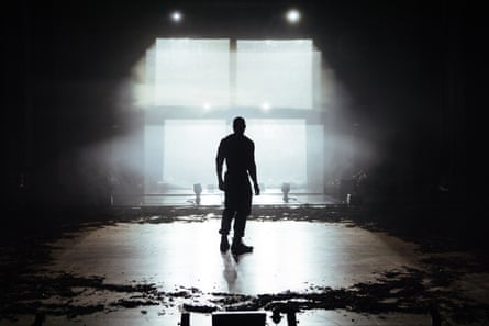 Arinzé Kene lit from behind on stage in Kohlhaas.