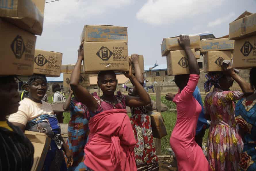 Residents of Oworonshoki slum in Lagos carry food parcels distributed by the Lagos Food Bank Initiative.