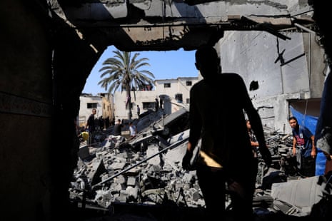 A Palestinian watches the house reduced to rubble in Deir Al-Balah.