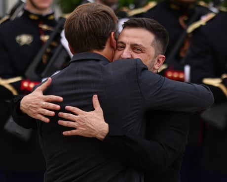 Emmanuel Macron and Volodymyr Zelenskyy embrace as the Ukrainian president is welcomed at the Élysée Palace in Paris on the eve of talks with allies