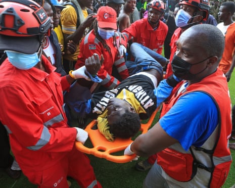 Red Cross officials carry an injured man.