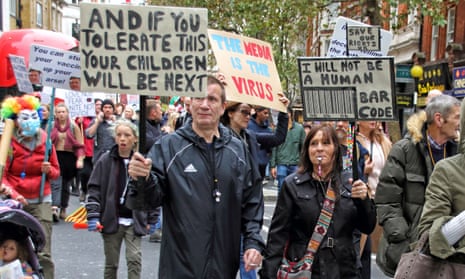 Demonstrators march through Leicester Square holding placards