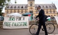 A passerby wearing a kippah pushes his bicycle past a banner reading "Jews for a free Palestine" at Oxford University on 7 May 2024, as a pro-Palestinian camp has been set up on the campus.