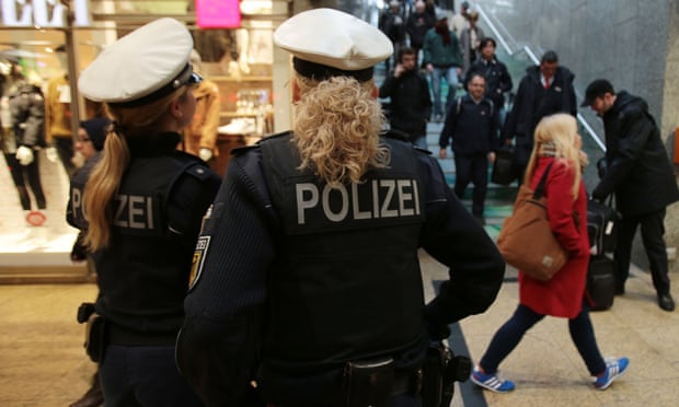 Police officers patrolling and watching over travellers inside Cologne Main Station.