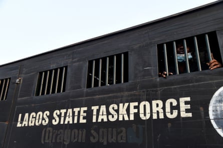 A black police truck with barred windows, with ‘Lagos state taskforce’ written on it.