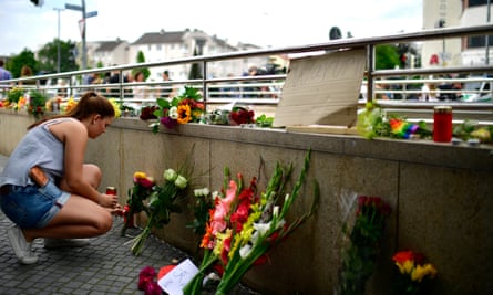 A girl lays flowers and candles outside the Olympia shopping centre on Saturday morning.