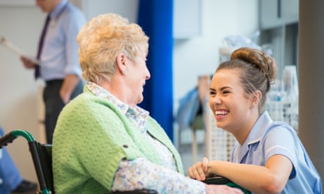 senior woman laughing with nurse on the ward