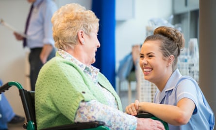 Senior woman laughing with nurse on the ward or nursing home
