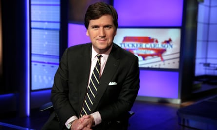 Tucker Carlson poses for photos in a Fox News Channel studio.