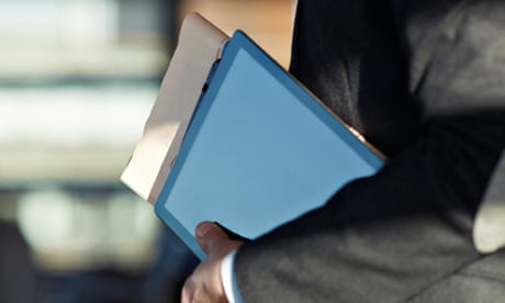 Businessman holding tablet, newspaper and Notebook