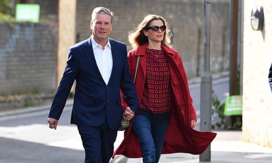 Keir and Victoria Starmer walking hand in hand along a street