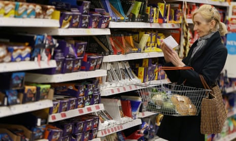 A shopper checks her shopping list in a supermarket.