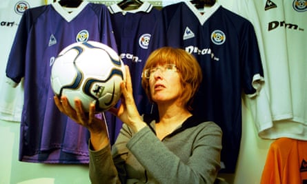 Dream Team producer Jane Hewland holding a football in front of Harchester United shirts hanging on a wall