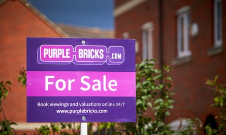 A Purple Bricks estate agents for sale sign outside a house on a modern housing estate