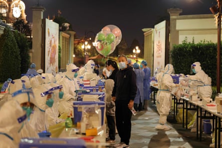 This file photo taken on October 31, 2021 shows medical personnel testing visitors for the Covid-19 coronavirus at Disneyland in Shanghai after a single coronavirus case was detected at the park.