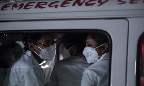 Health workers in Kerala leave in an ambulance