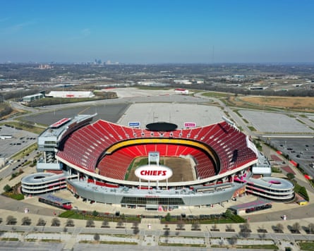 An overhead view of Arrowhead Stadium set against the backdrop of parking lots with Kansas City on the horizon.