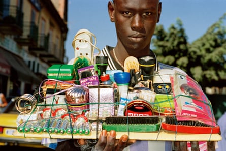 A man holding a tray of small items for sale, on a street in Dakar, Senegal, in 2001