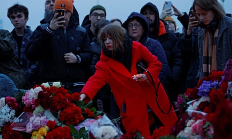 A woman lays flowers at a makeshift memorial to the victims of a shooting attack set up outside the Crocus City Hall concert venue in the Moscow Region, Russia, March 23, 2024.