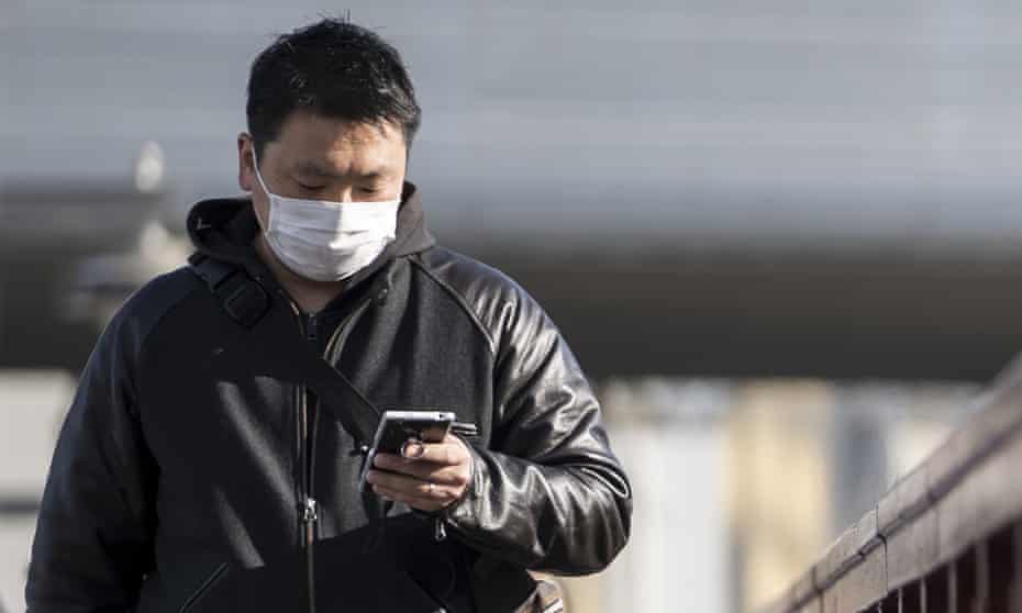 Man in mask with phone. Covid pandemic news dominated Australia’s most popular Google search terms of the year in 2021.